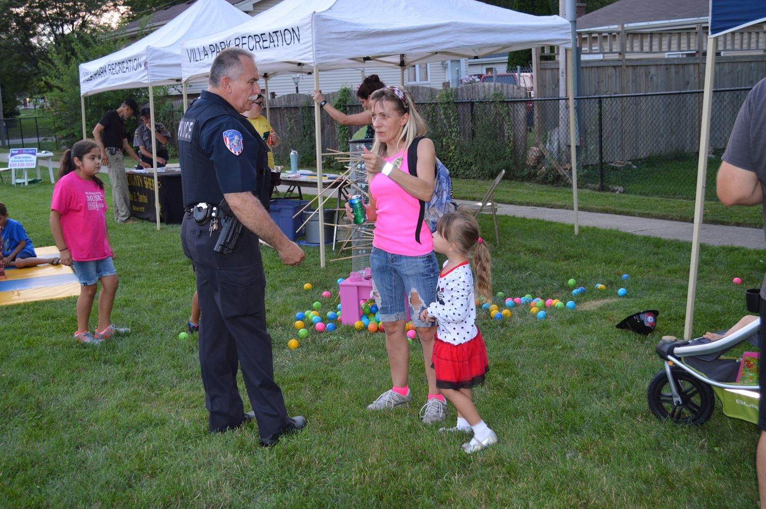 A Villa Park Police Officer stops to talk with a woman at a National Night Out event at the Iowa Community Center, Aug. 2.